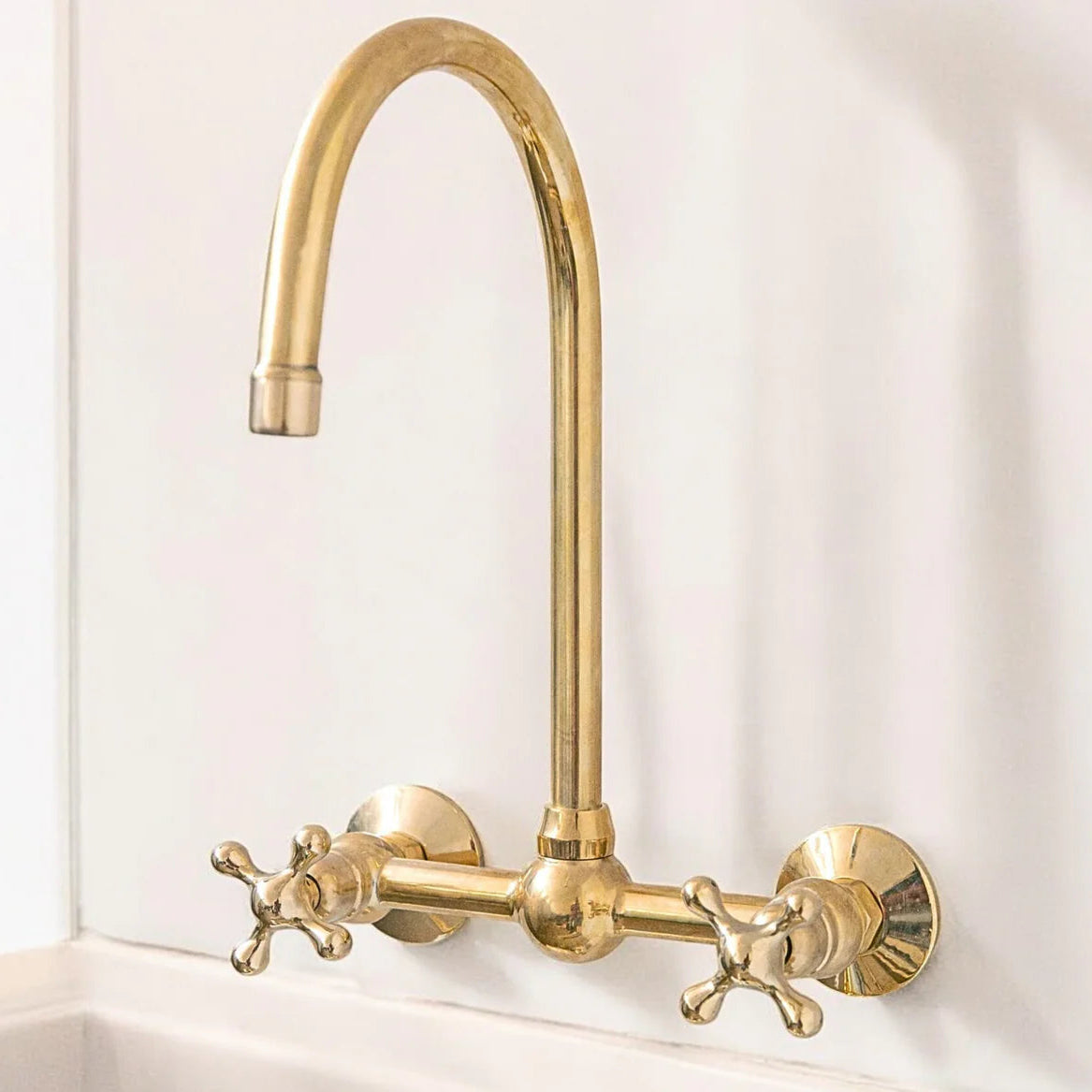 Unlacquered brass wall mount bridge faucet with gooseneck spout and ball center
