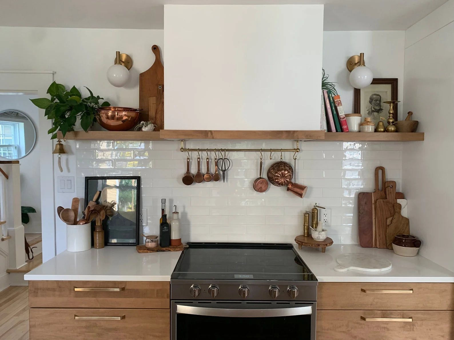 Unlacquered brass ceiling mounted pot rail with S-hooks holding copper pans