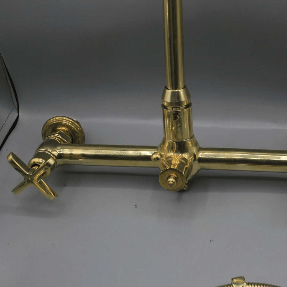 Unlacquered brass wall mount kitchen faucet with sprayer, 8 inch spread
