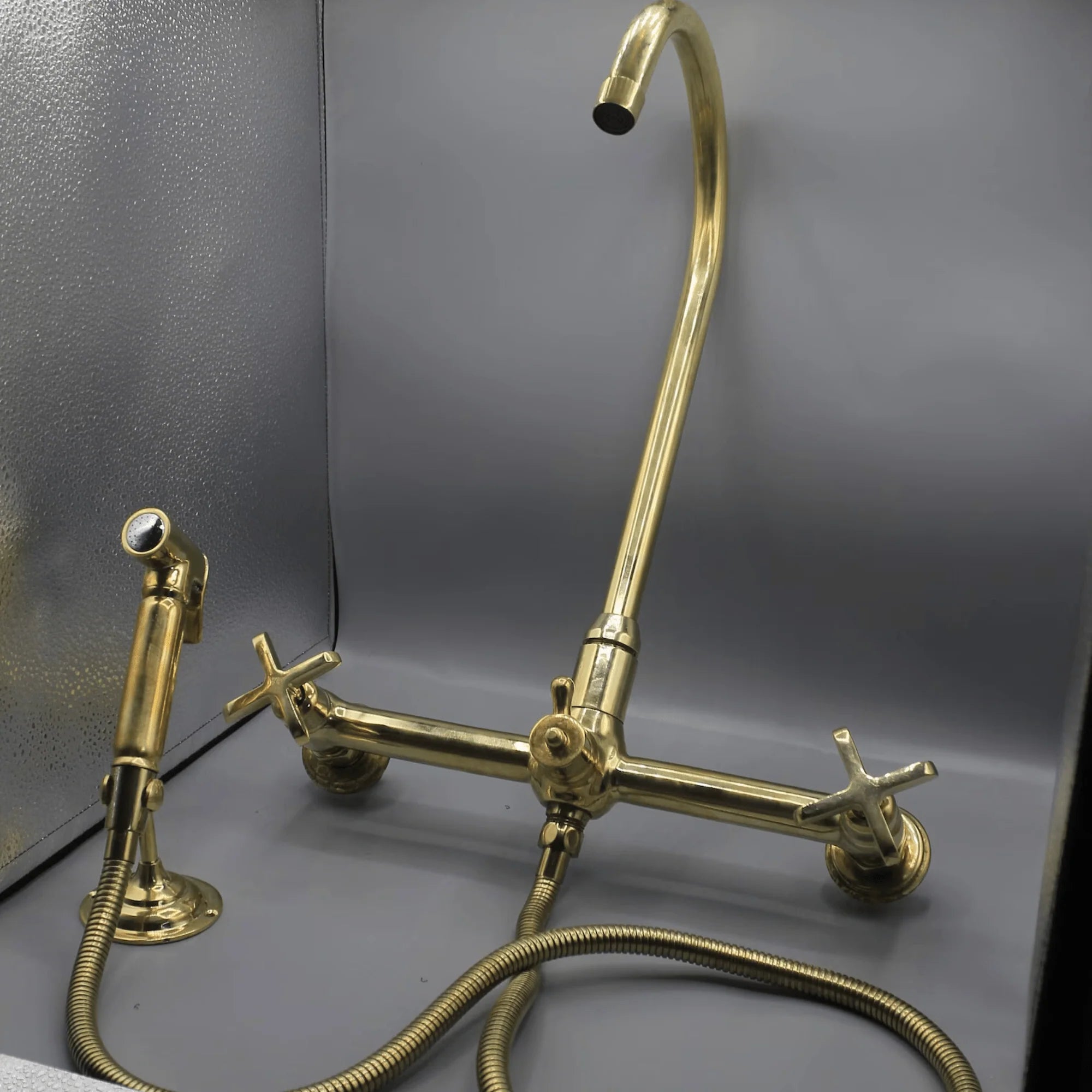 Unlacquered brass wall mount kitchen faucet with sprayer, 8 inch spread
